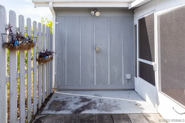 a view of a hallway to a livingroom with wooden floor and stairs