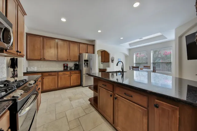 a kitchen with stainless steel appliances granite countertop a sink and cabinets