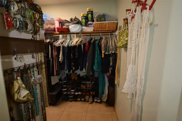 a view of walk in closet with clothes and shoes