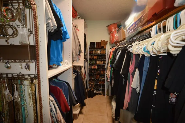 a view of walk in closet with clothes and shoes