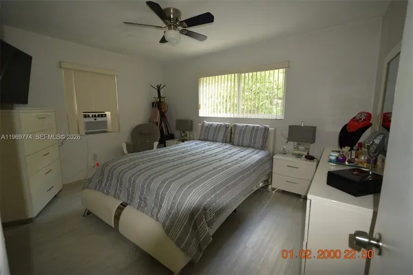 a bedroom with a bed and a flat tv screen on the dresser