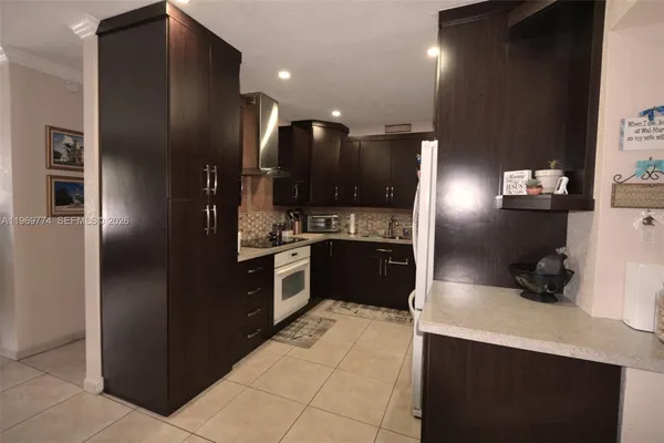 a kitchen with stainless steel appliances kitchen island granite countertop a refrigerator and a sink
