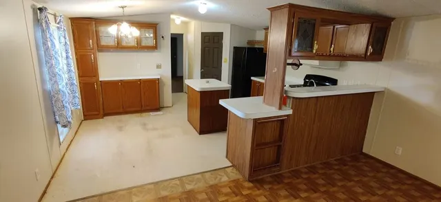 a view of kitchen with stainless steel appliances granite countertop a refrigerator and a stove