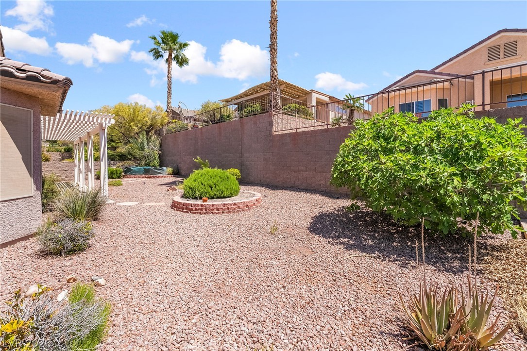 3033 Hartsville Road Henderson, NV 89052 - Photo 39 of 41 A tiered landscape with gravel pathways, lush plantings, and a relaxing covered patio awaits.