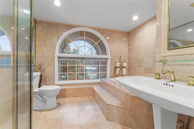 a bathroom with a sink a toilet and a large mirror