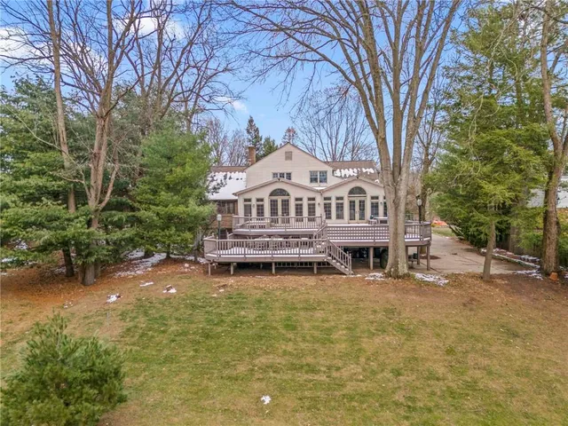 a view of a house with a big yard and large trees