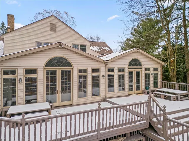 a view of a white house with a small yard and wooden fence