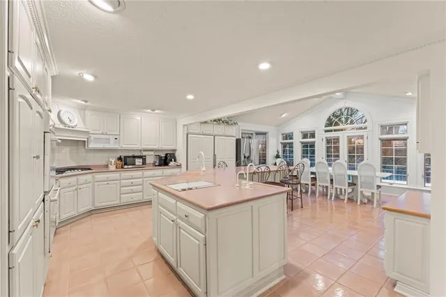a large kitchen with kitchen island a sink table and chairs
