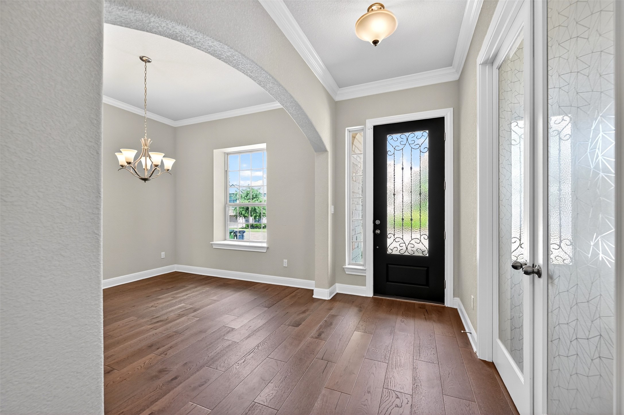 1201 Positano Pass Leander, TX 78641 - Photo 8 of 40 Entryway featuring a decorative glass front door with wrought iron accents, sidelight window, and wood-finish flooring