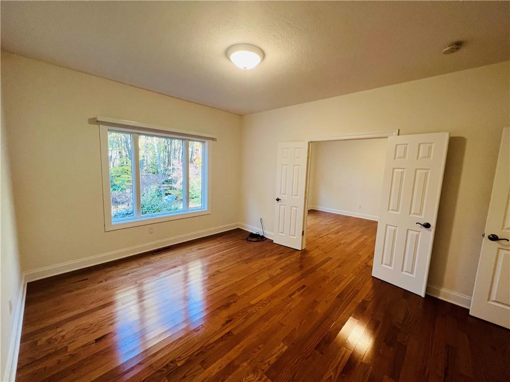 232 Devils Backbone Road New Castle, PA 16102 - Photo 12 of 25 an empty room with wooden floor and windows