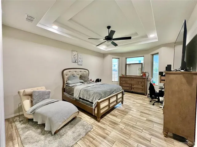 a living room with furniture a flat screen tv and a ceiling fan