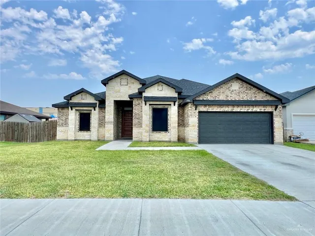 front view of a house with a yard and a garage
