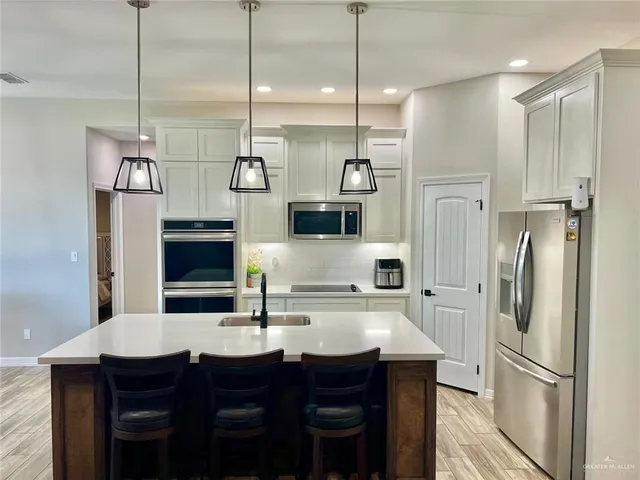 a kitchen with refrigerator cabinets and wooden floor