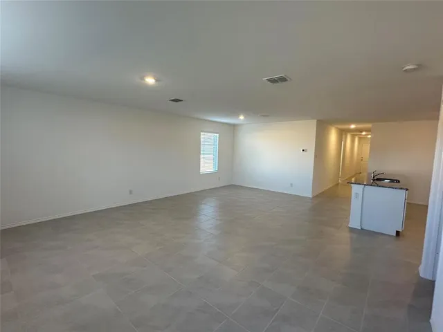 an empty room with windows and cabinet