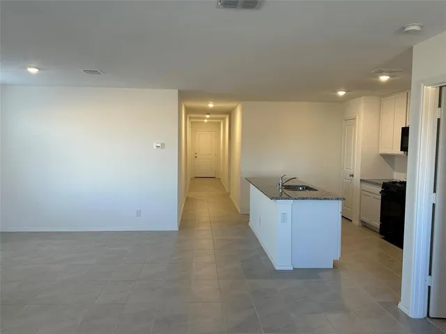 a large kitchen with stainless steel appliances a large counter top a stove and a refrigerator