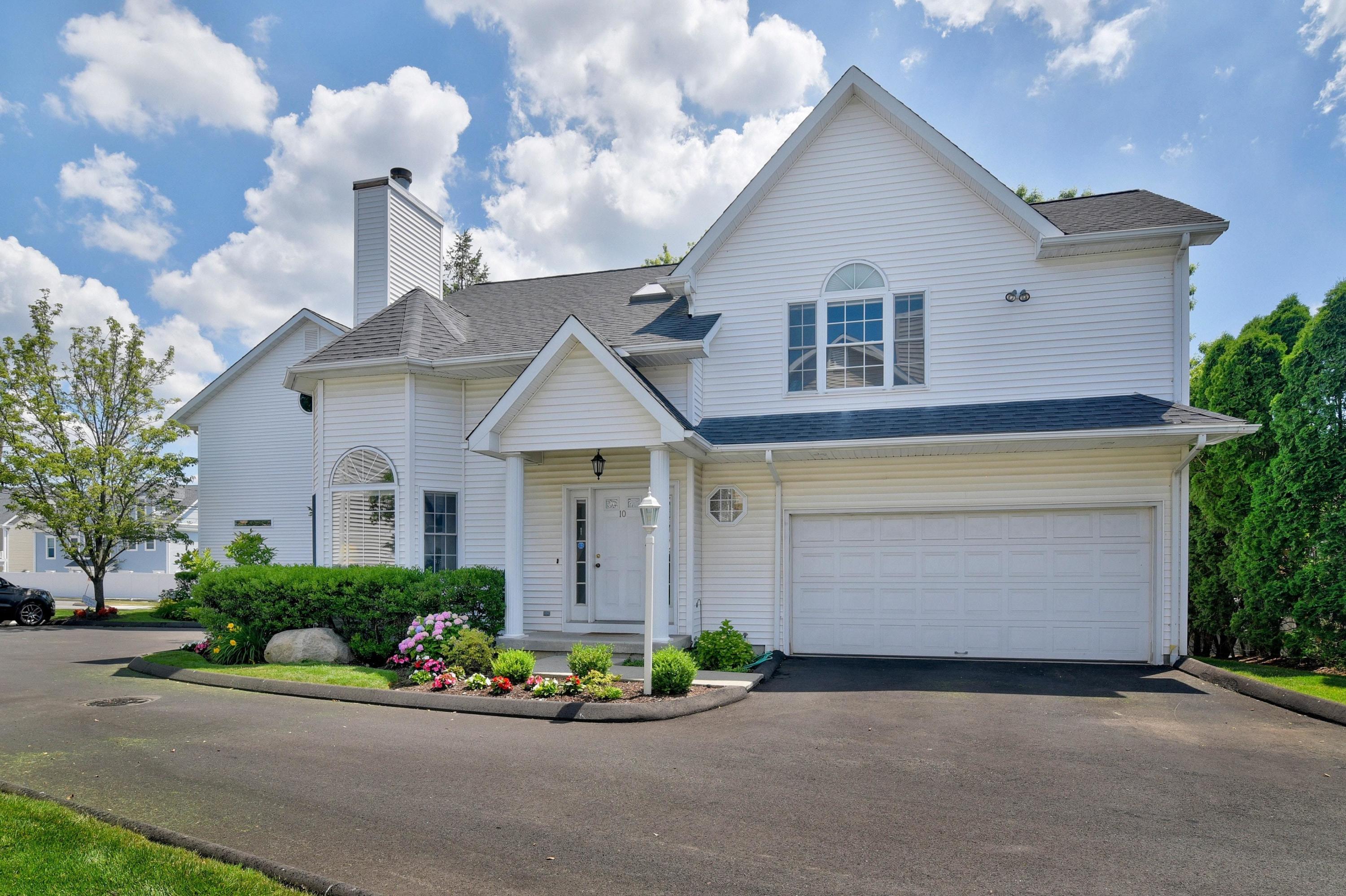 168 Colonial Road, Unit 10 Stamford, CT 06906 - Photo 2 of 27 a front view of a house with a yard and garage