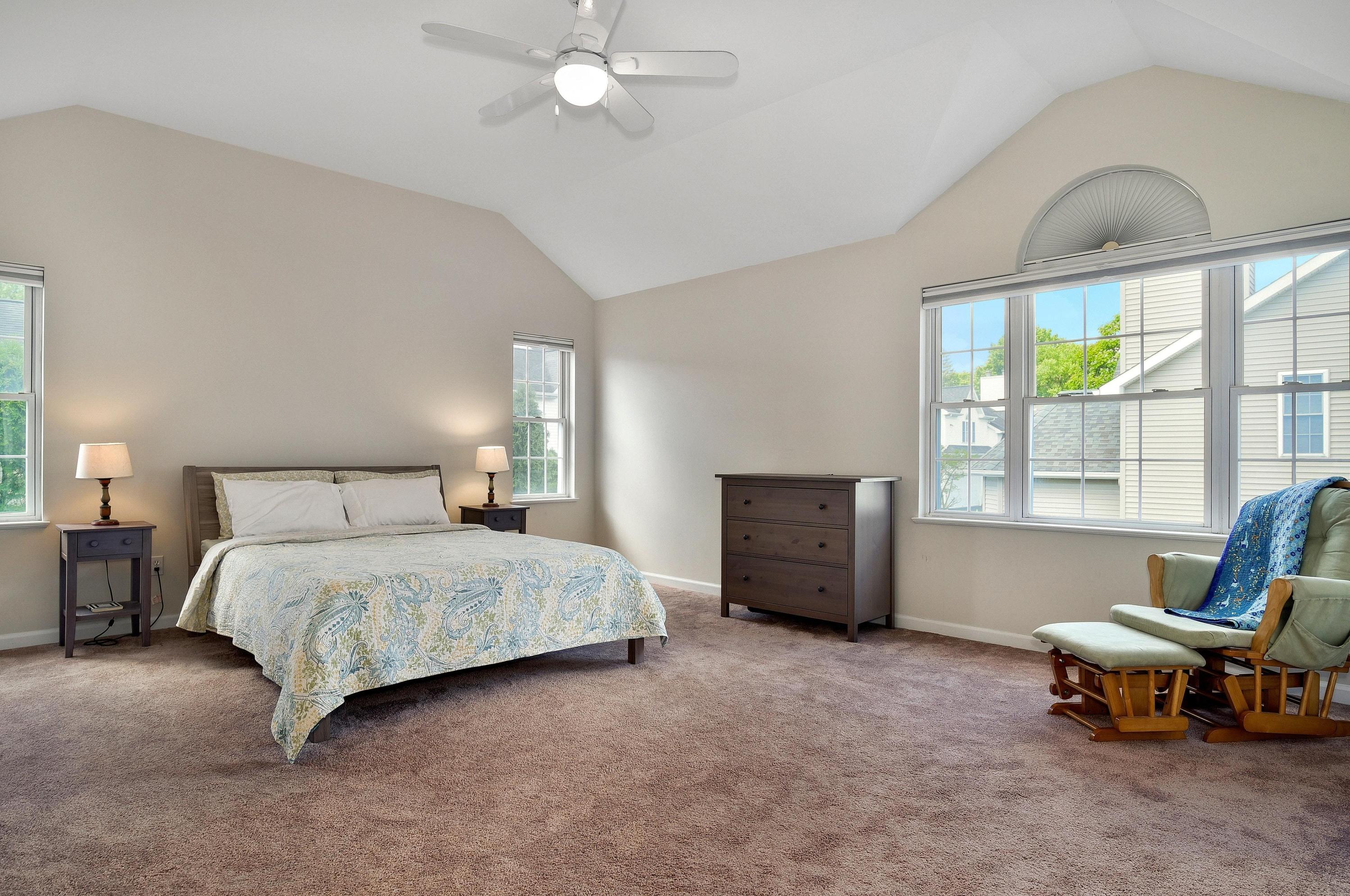 168 Colonial Road, Unit 10 Stamford, CT 06906 - Photo 15 of 27 a spacious bedroom with a bed and a chandelier