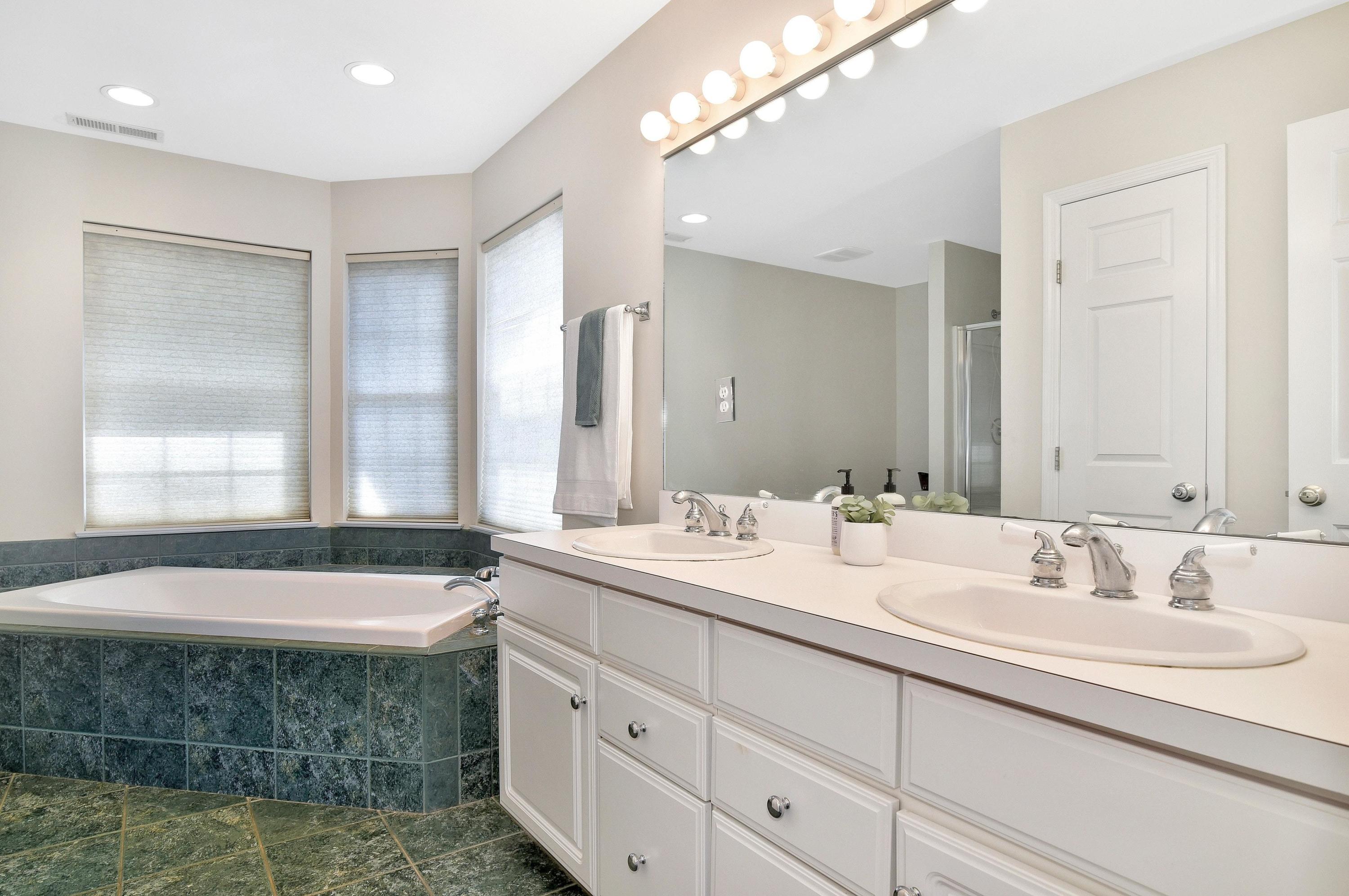 168 Colonial Road, Unit 10 Stamford, CT 06906 - Photo 17 of 27 a bathroom with a bathtub a double vanity sink and mirror