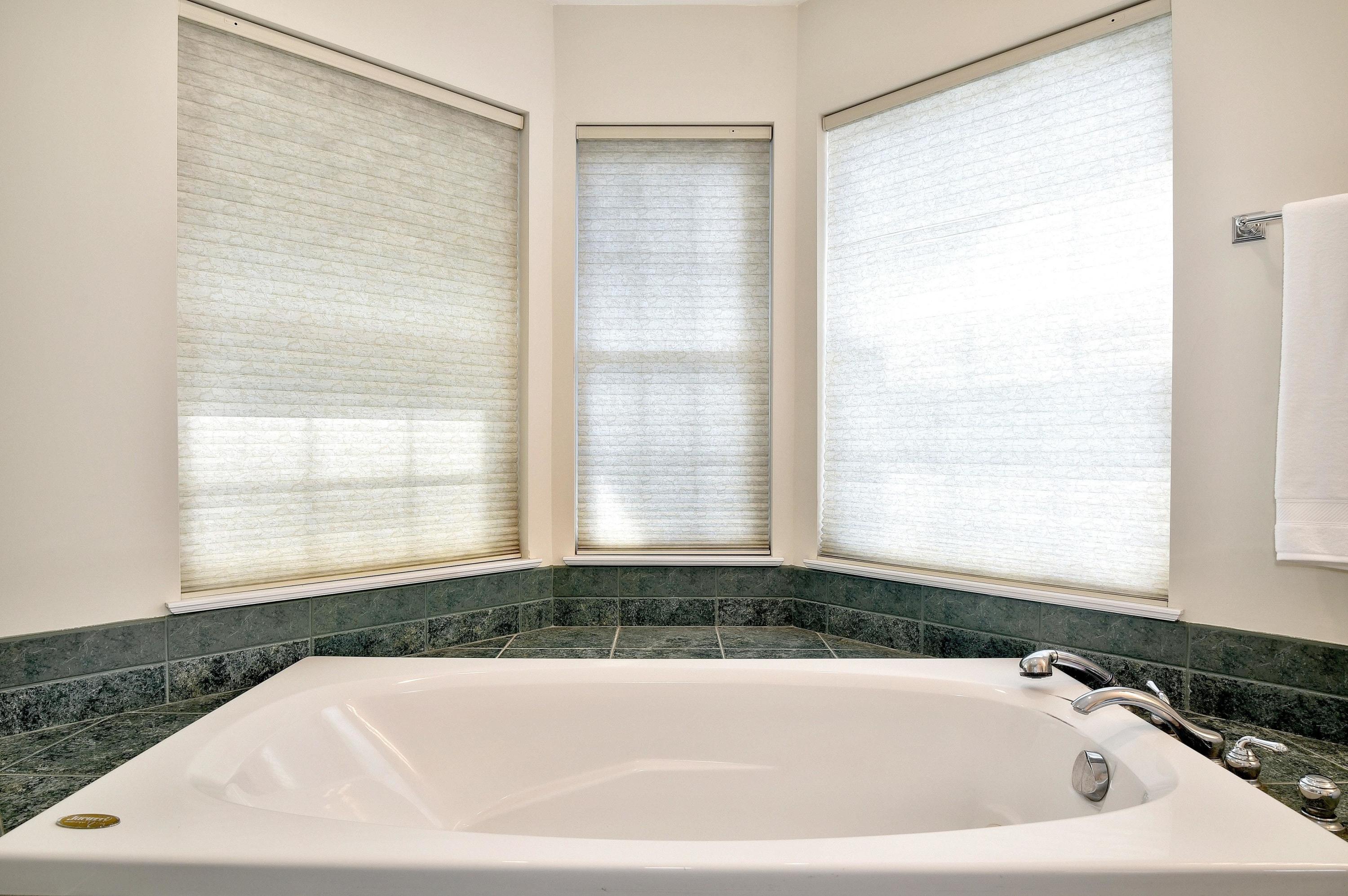 168 Colonial Road, Unit 10 Stamford, CT 06906 - Photo 18 of 27 a white bath tub sitting in a bathroom next to a window