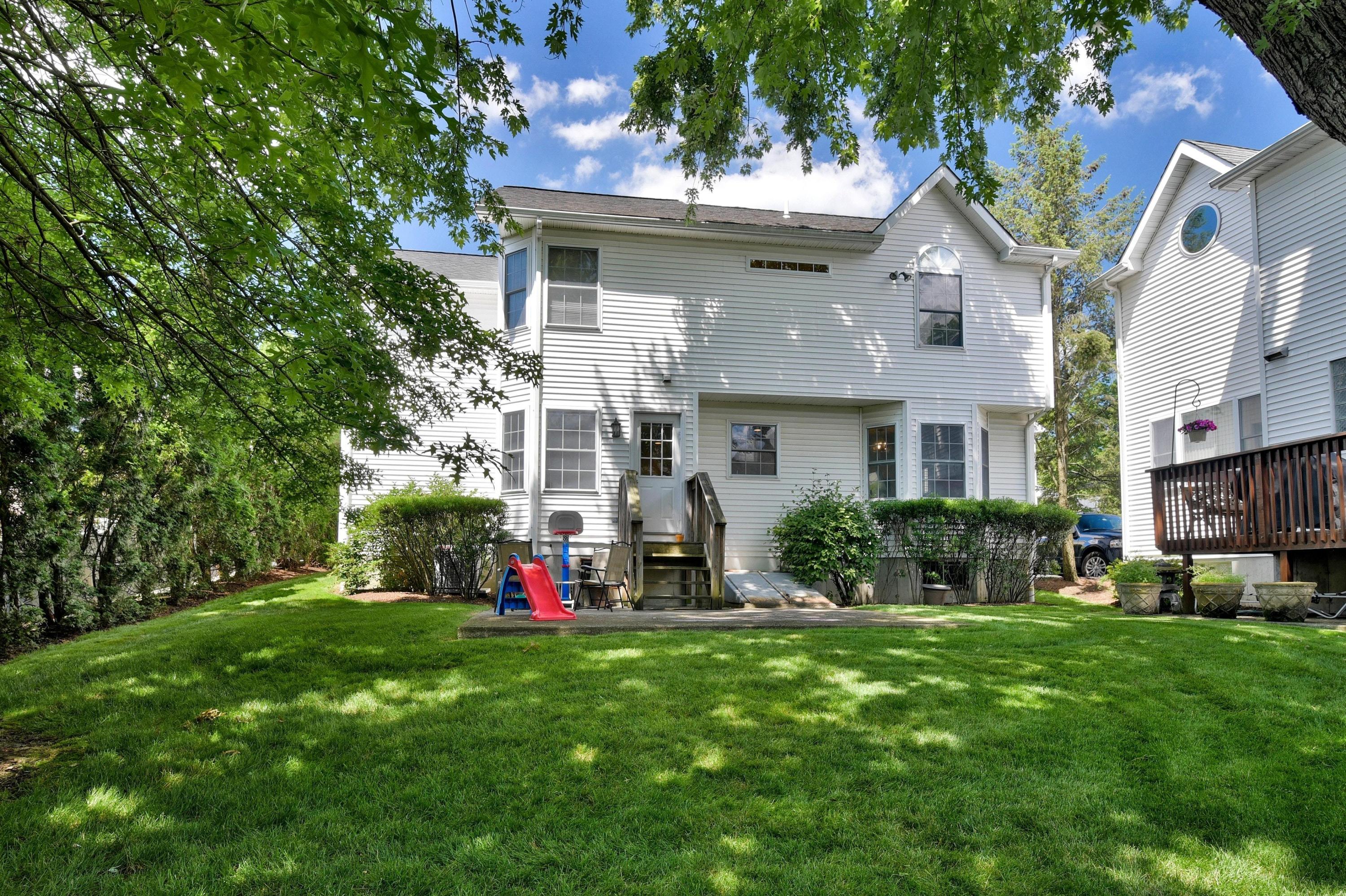 168 Colonial Road, Unit 10 Stamford, CT 06906 - Photo 23 of 27 a front view of a house with a yard and tree