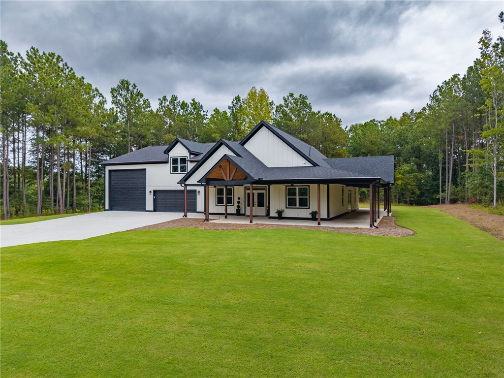 147 McAlister Road West Union, SC 29696 - Photo 1 of 50 A modern farmhouse facade stands out against a backdrop of towering green pines.