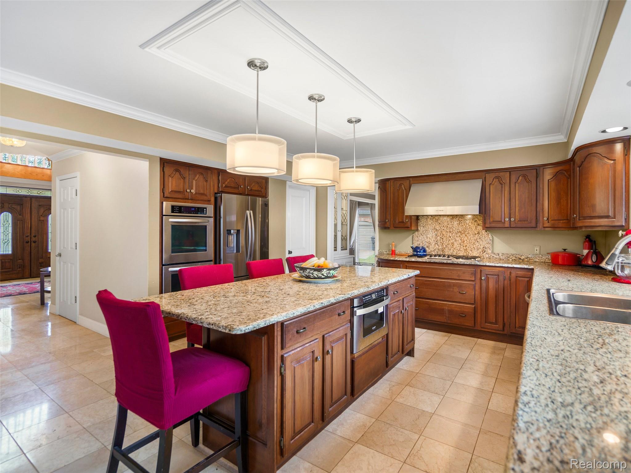 5724 Murfield Drive Rochester, MI 48306 - Photo 47 of 99 Kitchen featuring a kitchen bar, ornamental molding, light stone countertops, hanging light fixtures, and stainless steel appliances