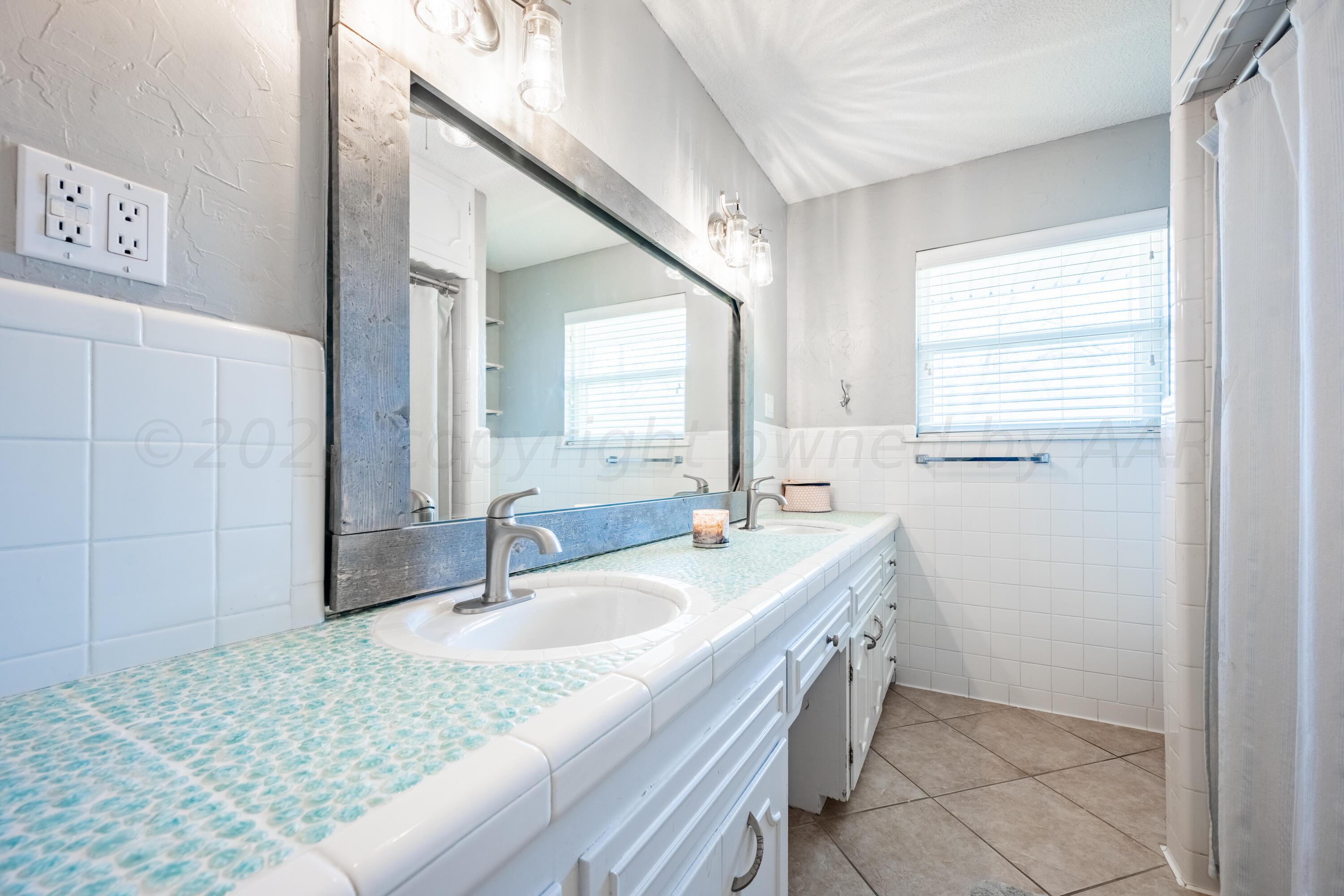 3313 Bedford Road Amarillo, TX 79106 - Photo 18 of 24 a bathroom with a granite countertop sink and a mirror