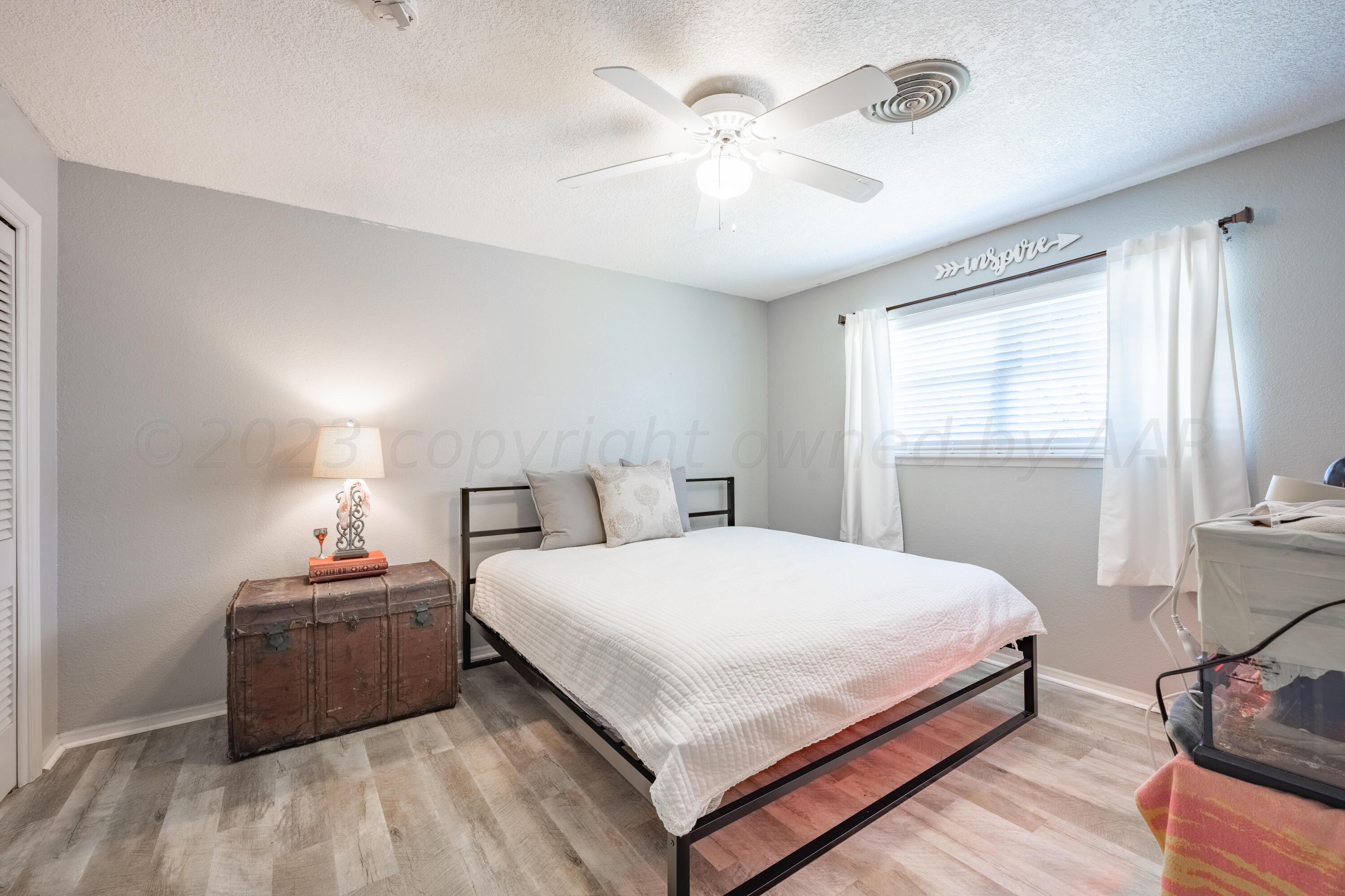 3313 Bedford Road Amarillo, TX 79106 - Photo 19 of 24 a bedroom with a bed and a chandelier