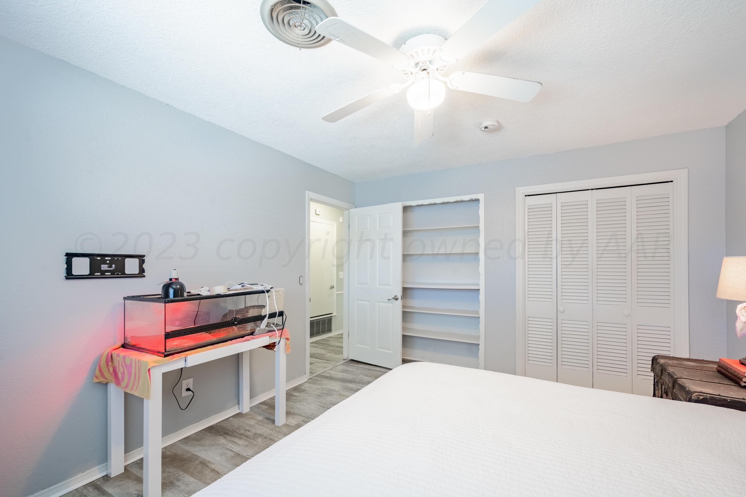 3313 Bedford Road Amarillo, TX 79106 - Photo 20 of 24 a bedroom with a bed and a chandelier
