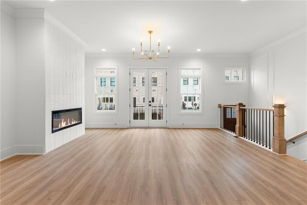 345 Sugarview Road Sugar Hill, GA 30518 - Photo 13 of 66 an empty room with wooden floor fireplace and windows