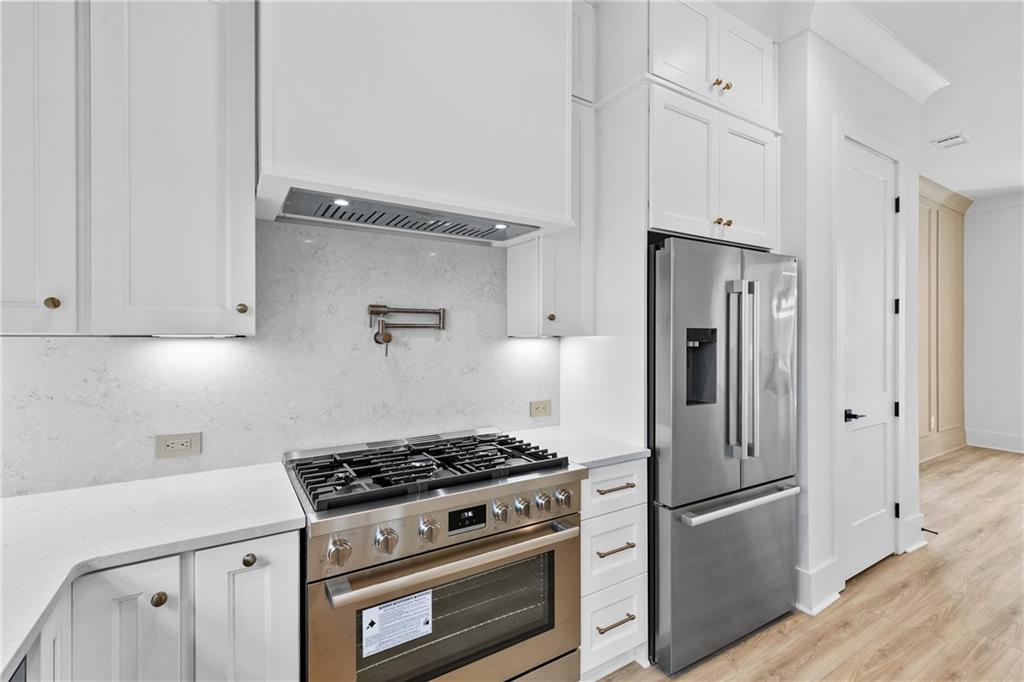 345 Sugarview Road Sugar Hill, GA 30518 - Photo 19 of 66 a kitchen with stainless steel appliances a stove a refrigerator and cabinets