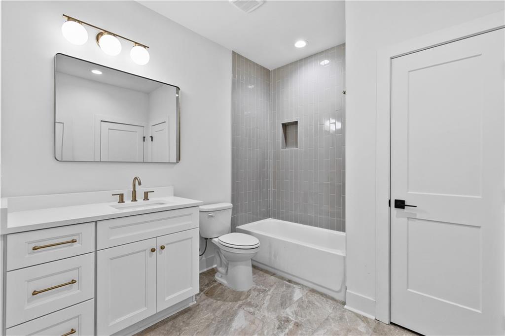 345 Sugarview Road Sugar Hill, GA 30518 - Photo 37 of 66 a bathroom with a toilet a sink a mirror a bathtub and vanity