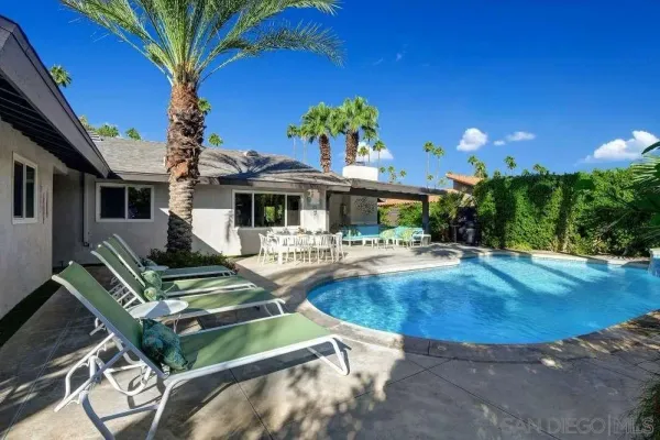 a view of a house with patio and a yard