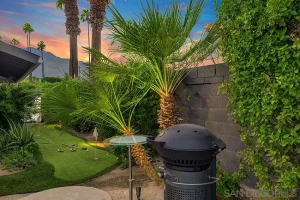 a view of a house with swimming pool lawn chairs and a fire pit