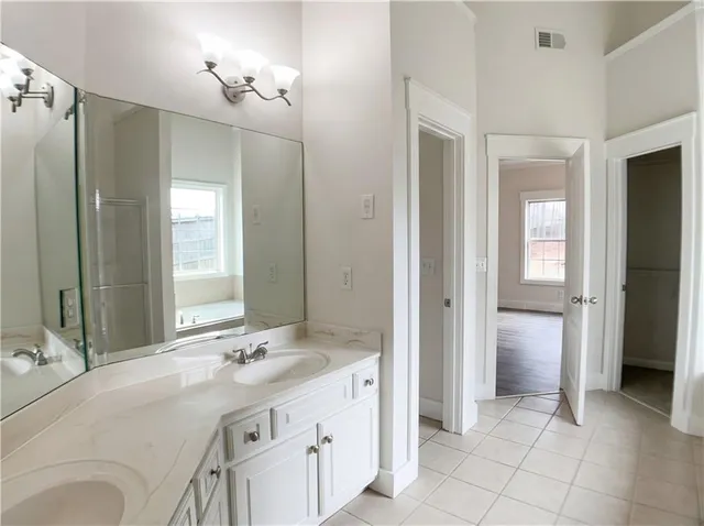 a spacious bathroom with a granite countertop sink a mirror and a shower