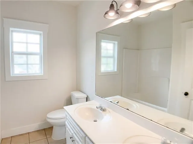 a bathroom with a sink a toilet and window