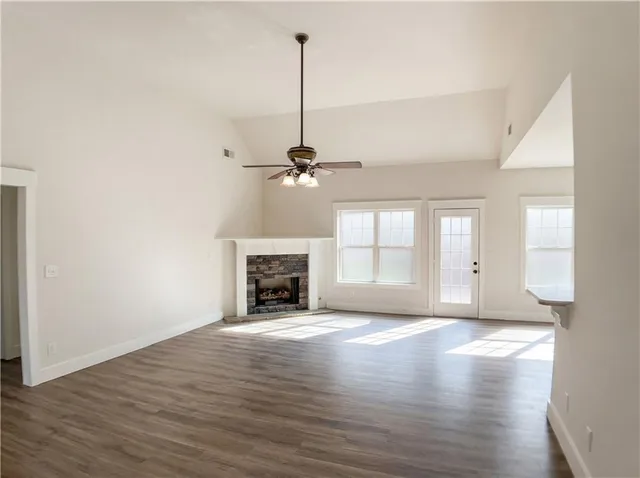 a view of empty room with wooden floor and fireplace