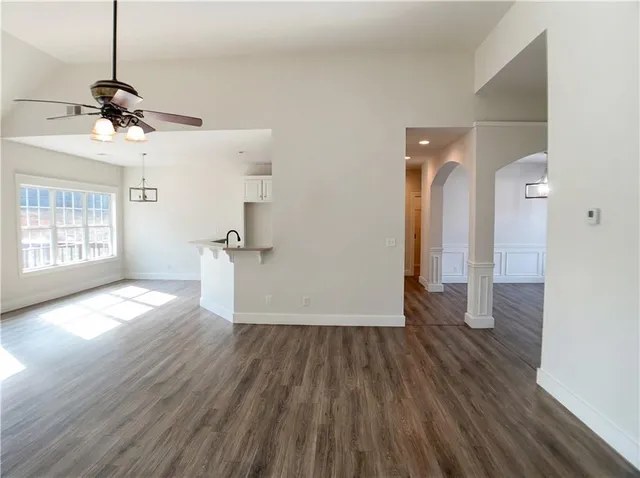 a view of a room with wooden floor and ceiling fan