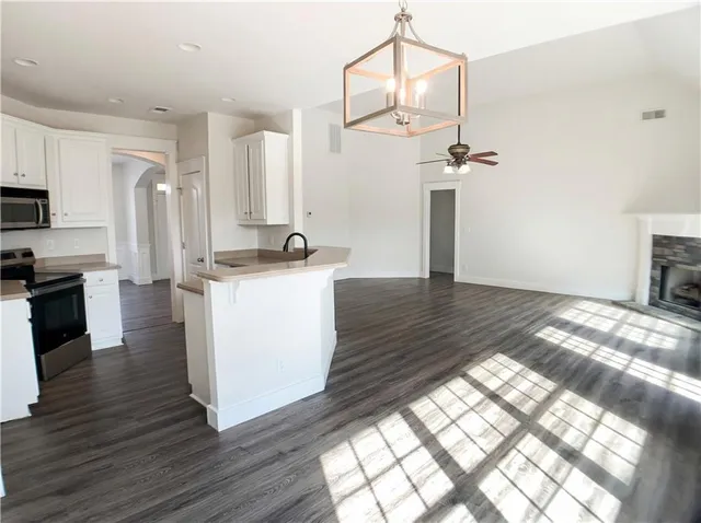 a kitchen with granite countertop a stove a sink and a refrigerator