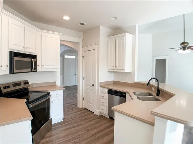 a kitchen with a sink appliances and cabinets