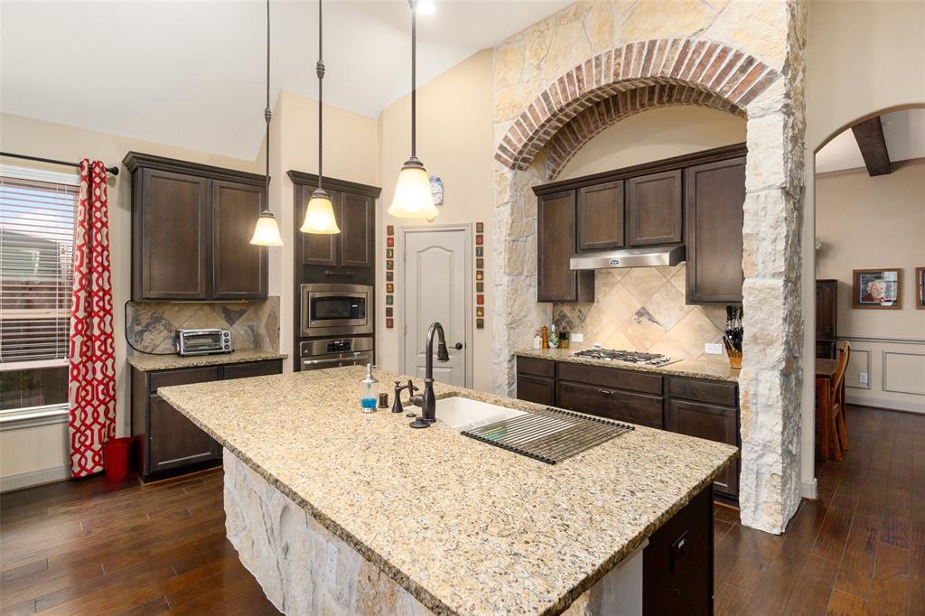 a kitchen with kitchen island granite countertop a sink a counter top space and appliances