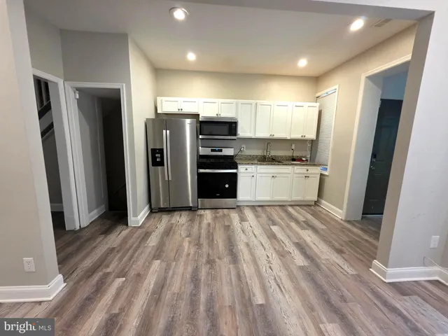 a kitchen with stainless steel appliances a refrigerator and a stove top oven