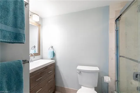 a bathroom with a sink vanity mirror and toilet