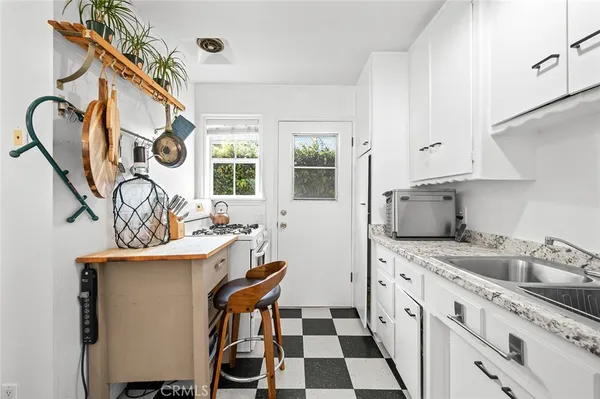 a kitchen with stainless steel appliances a sink a stove a refrigerator and cabinets