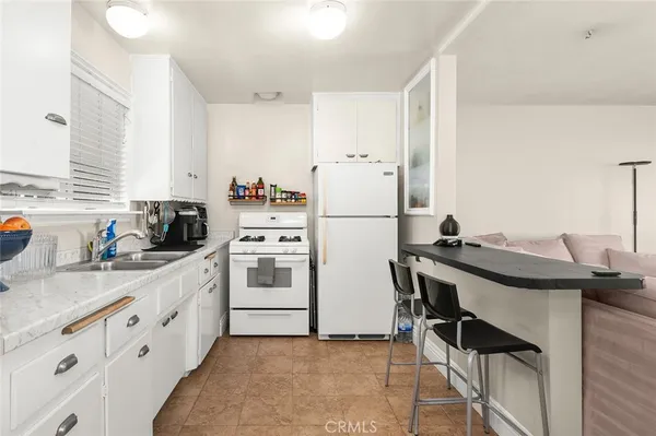 a kitchen with granite countertop a sink stove and refrigerator
