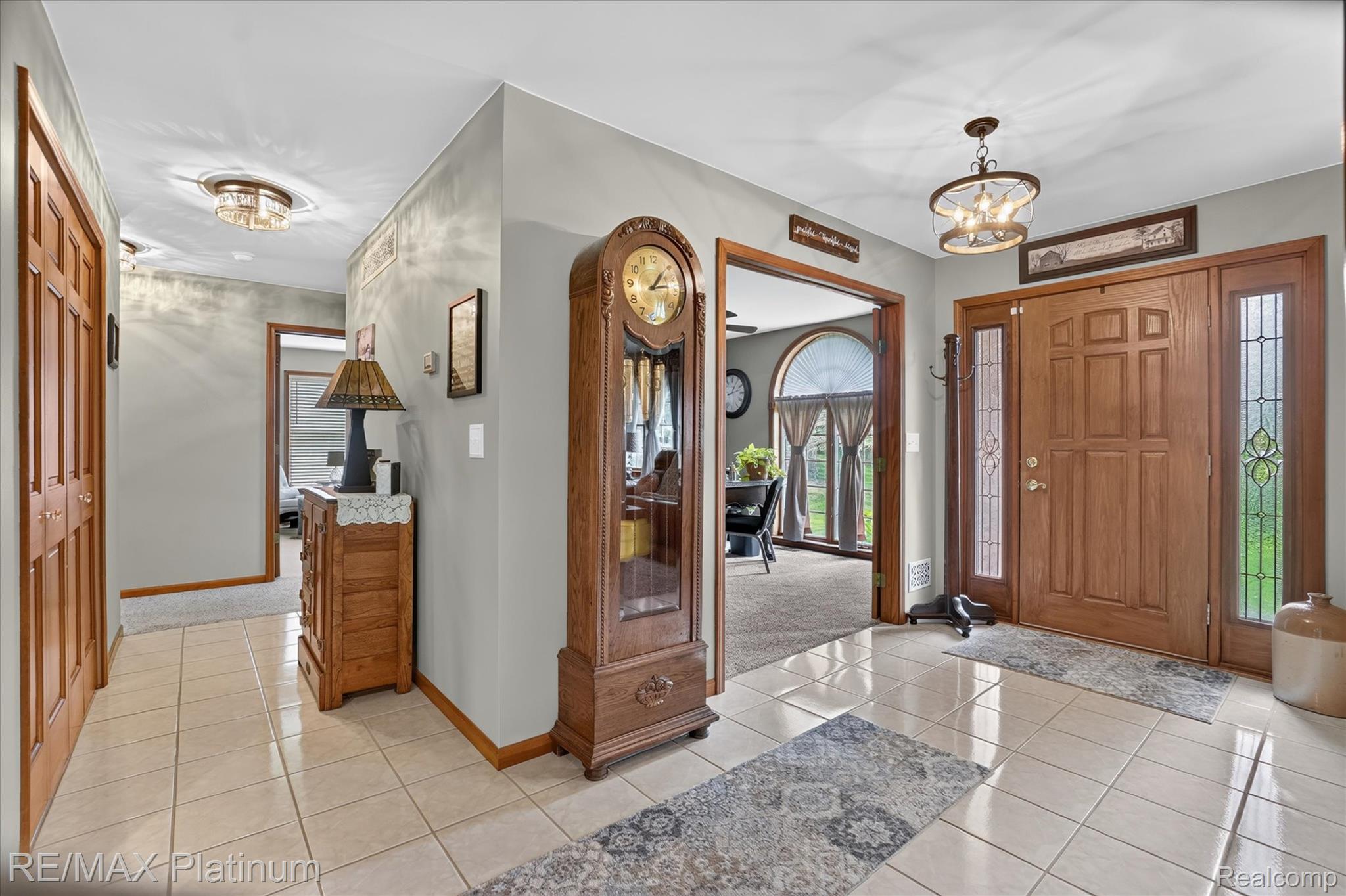 4457 Bradley Road Gregory, MI 48137 - Photo 42 of 79 Entryway featuring tile flooring, a wood-paneled door with decorative sidelights, and a decorative ceiling light fixture