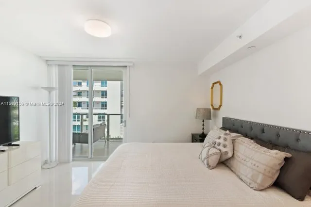 a bedroom with bed and flat screen tv