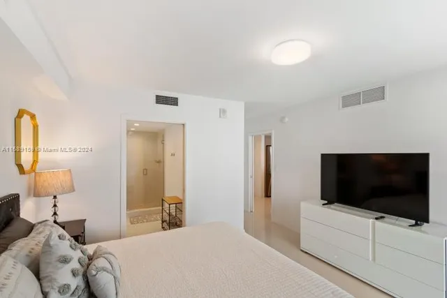 a bedroom with a flat screen tv and a bed