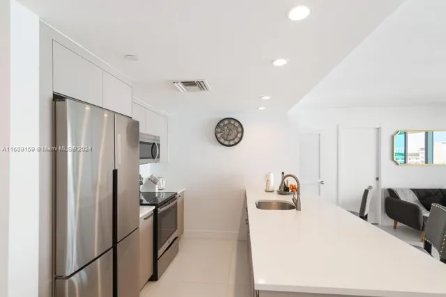 a kitchen with stainless steel appliances a refrigerator sink and microwave