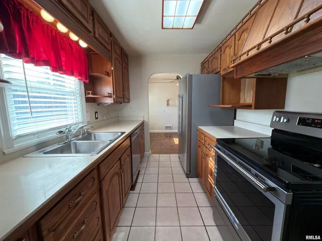 a kitchen with stainless steel appliances granite countertop a sink and a stove